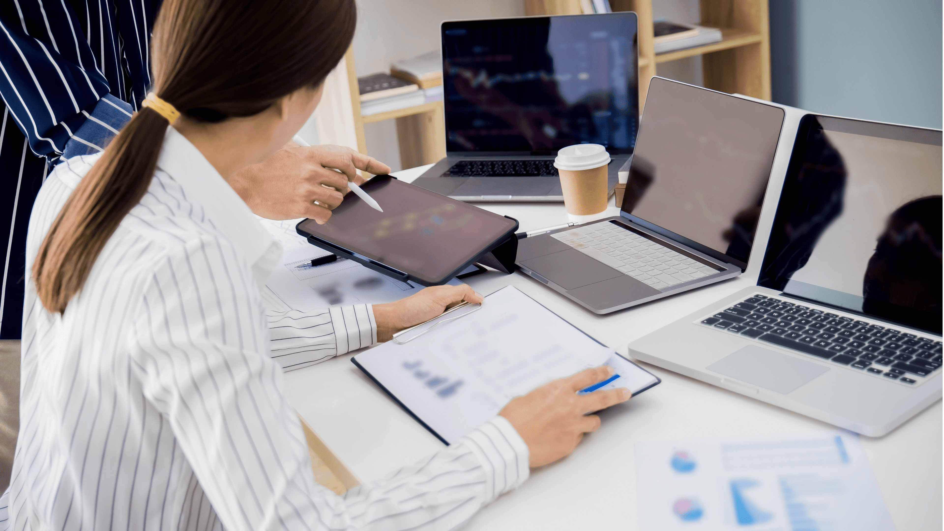 Woman working on tablet with laptop